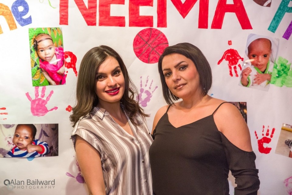 Family and friends in front of the NEEMA poster