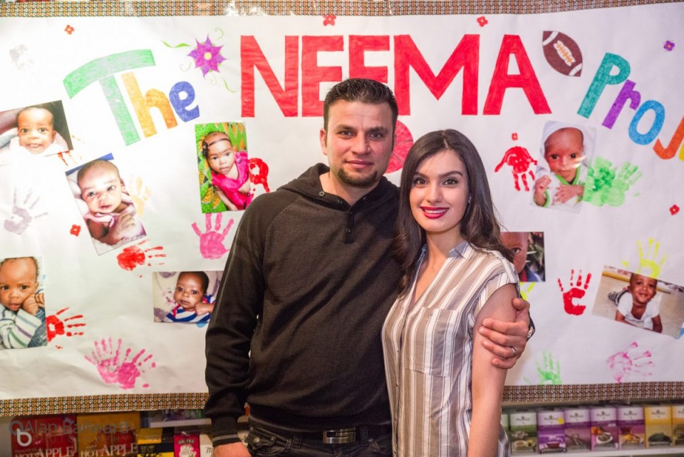 Family and friends in front of the NEEMA poster